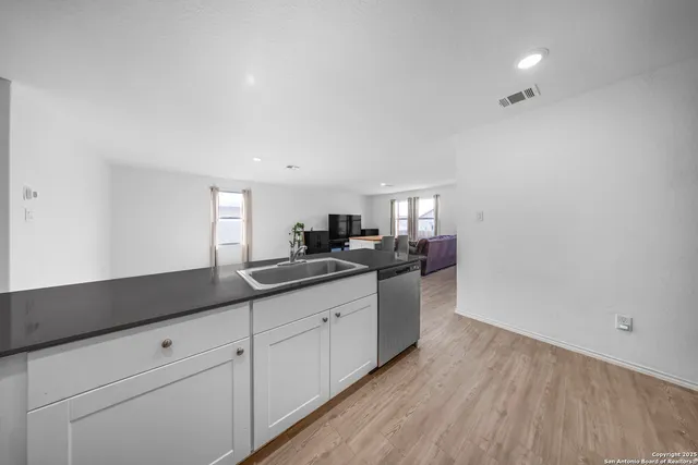 a kitchen with granite countertop white cabinets and sink