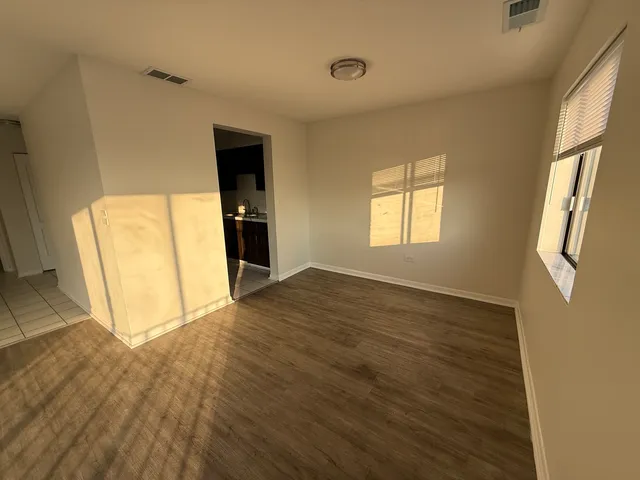an empty room with wooden floor and entrance