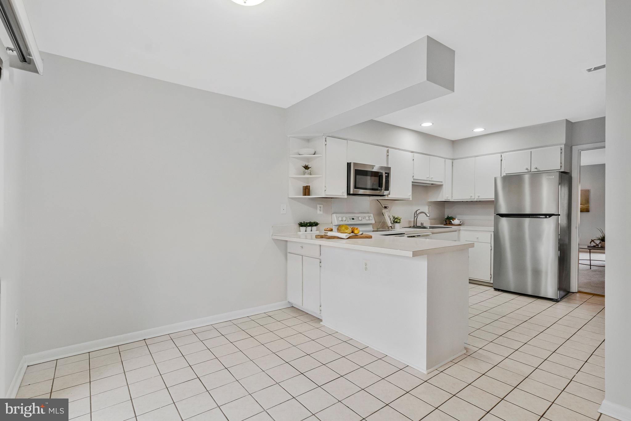2005 Wethersfield Court Reston, VA 20191 - Photo 17 of 43 a kitchen with white cabinets and refrigerator