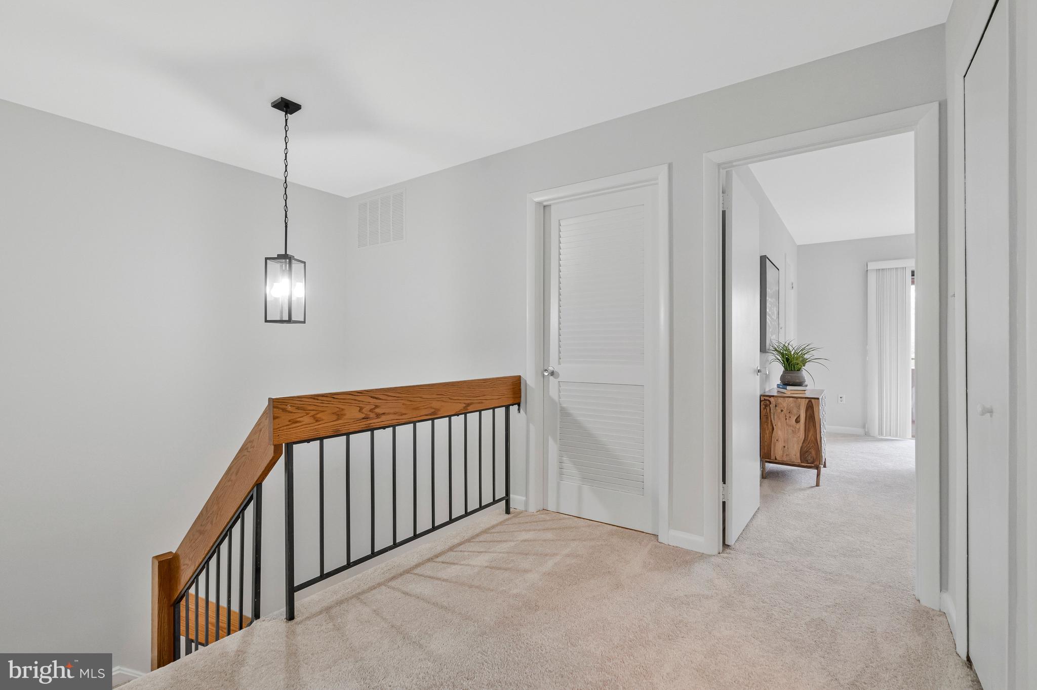 2005 Wethersfield Court Reston, VA 20191 - Photo 32 of 43 a view of a hallway with wooden floor and a chandelier