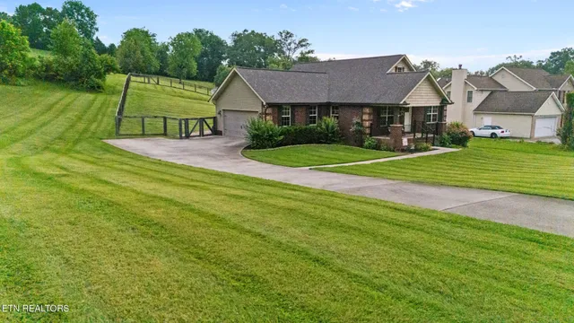 a view of house with a big yard and potted plants