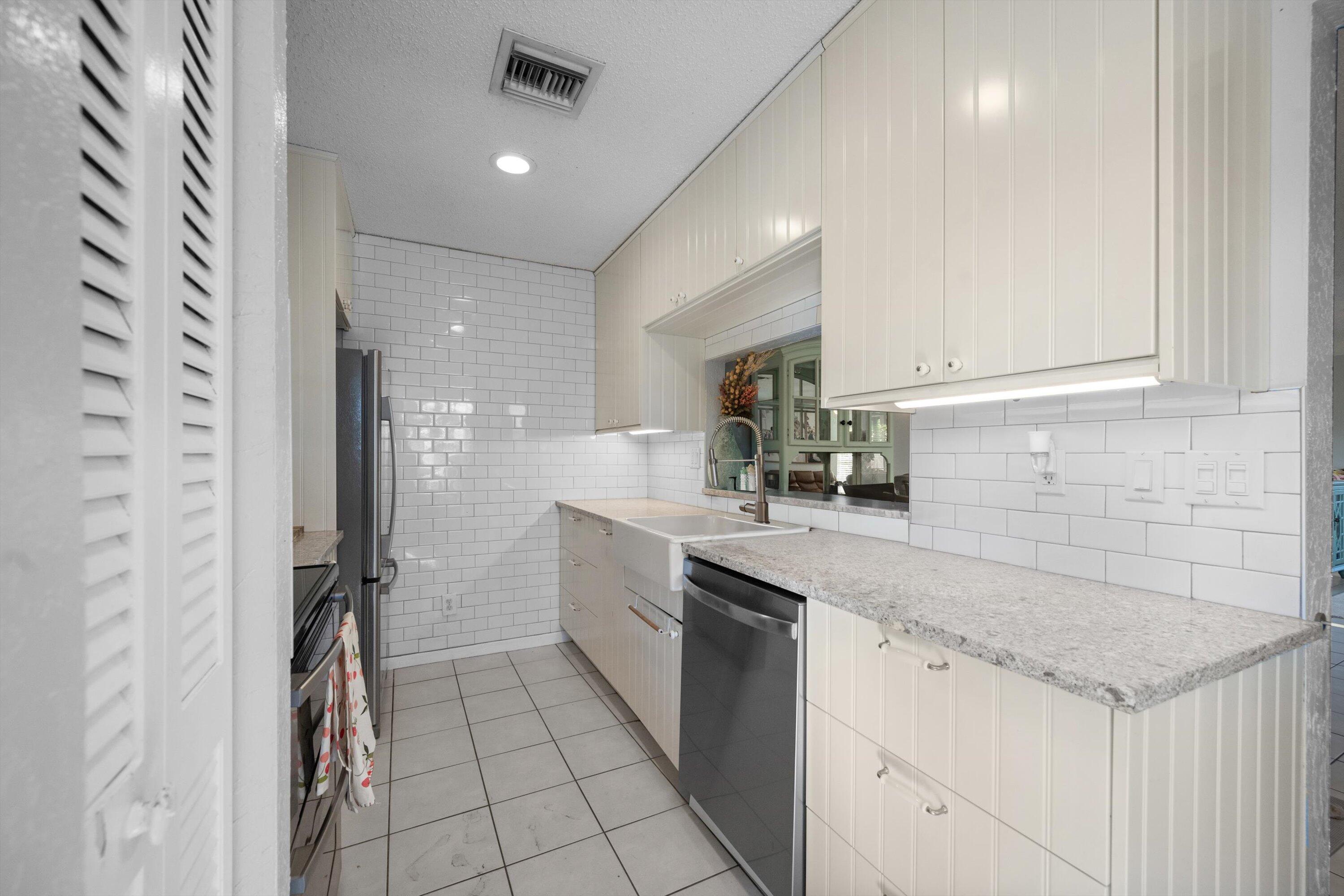 197 Southeast 1st Circle, Unit 15B Boynton Beach, FL 33435 - Photo 12 of 26 a kitchen with a sink appliances and cabinets