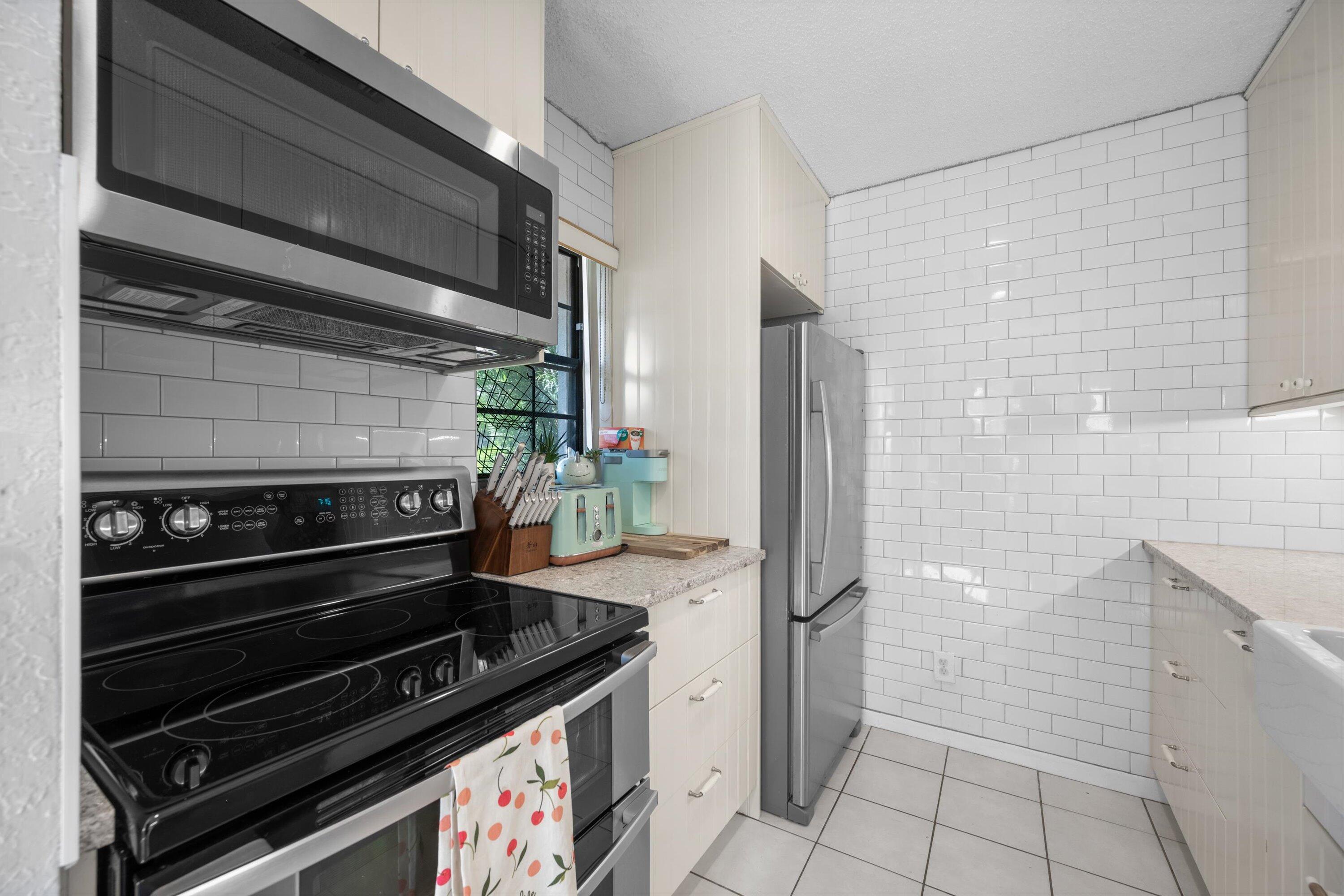 197 Southeast 1st Circle, Unit 15B Boynton Beach, FL 33435 - Photo 14 of 26 a kitchen with a stove and a microwave