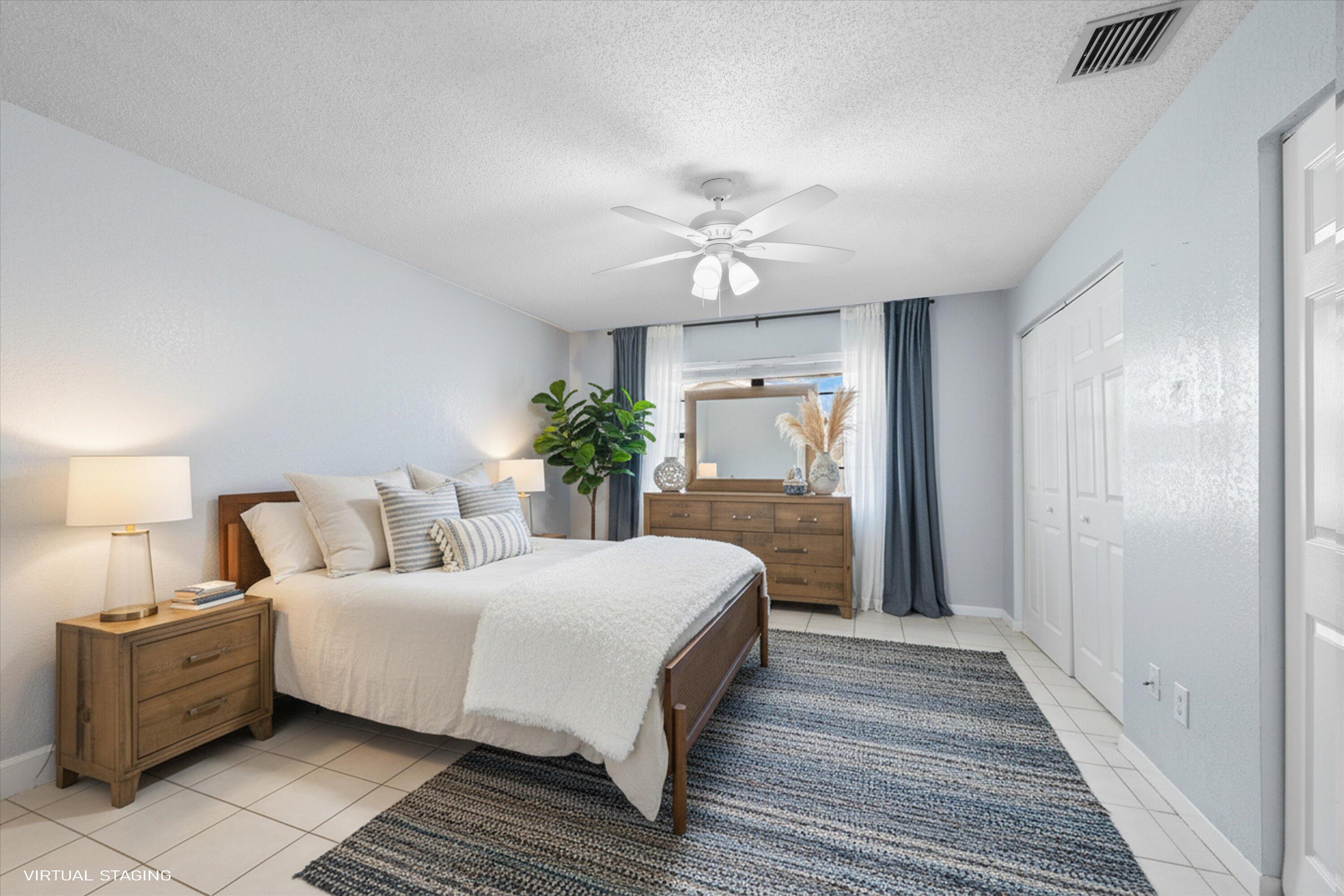 197 Southeast 1st Circle, Unit 15B Boynton Beach, FL 33435 - Photo 16 of 26 a bedroom with a large bed and a chandelier