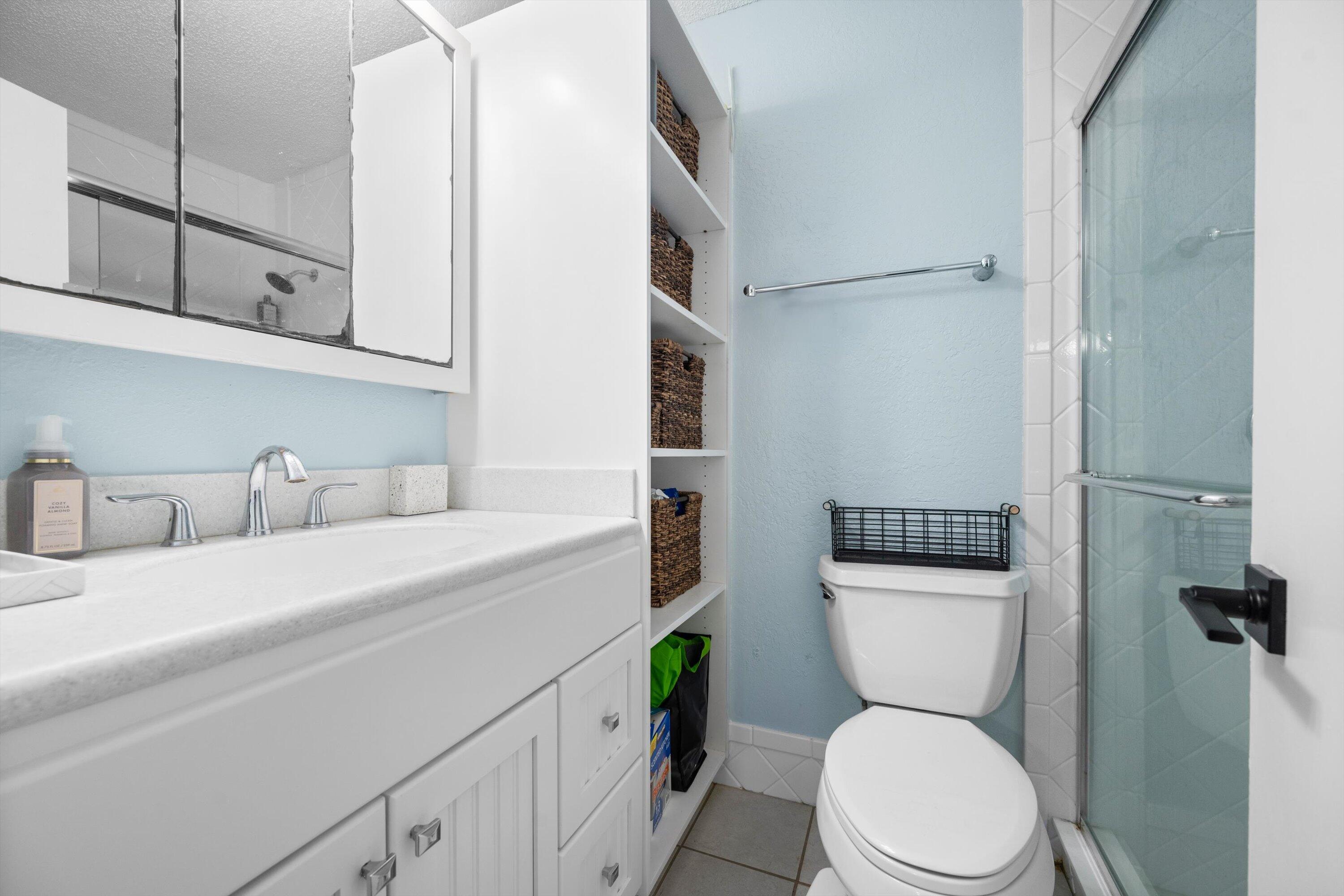 197 Southeast 1st Circle, Unit 15B Boynton Beach, FL 33435 - Photo 17 of 26 a bathroom with a toilet sink and mirror