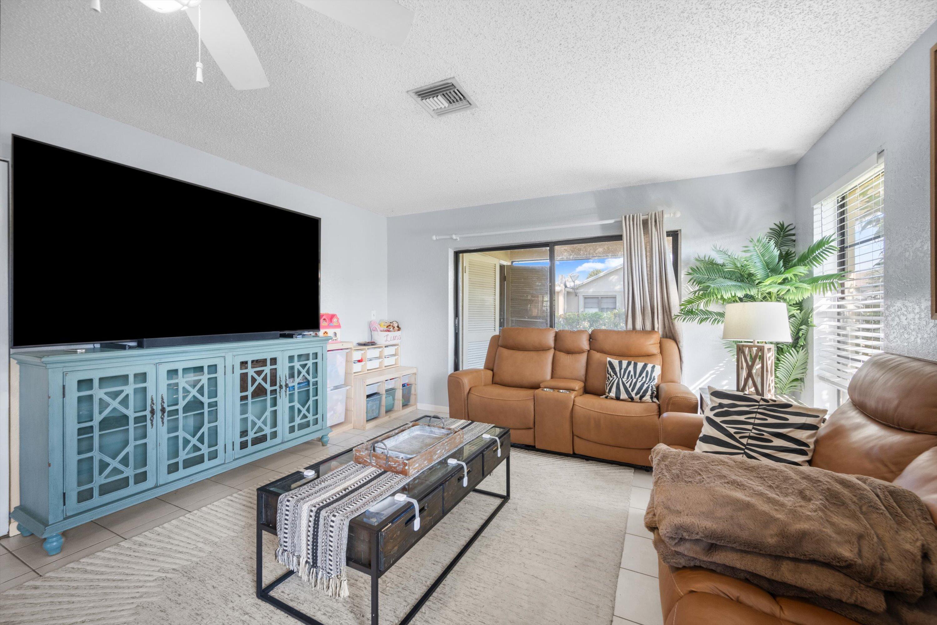197 Southeast 1st Circle, Unit 15B Boynton Beach, FL 33435 - Photo 6 of 26 a living room with furniture and a flat screen tv