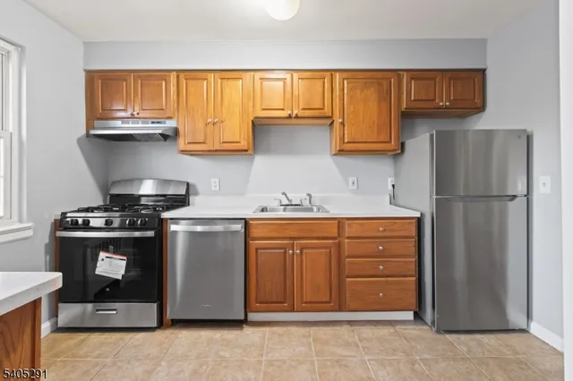 a kitchen with stainless steel appliances granite countertop a refrigerator stove and sink