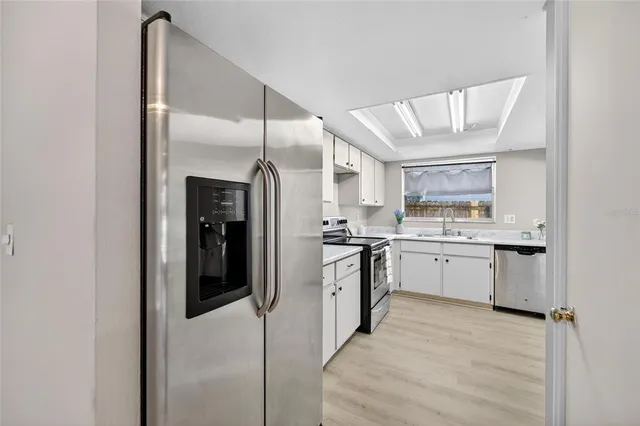 a kitchen with cabinets and steel appliances