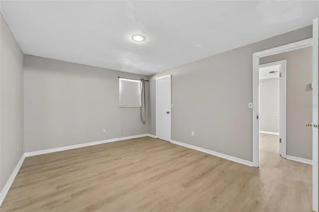 a view of an empty room with wooden floor