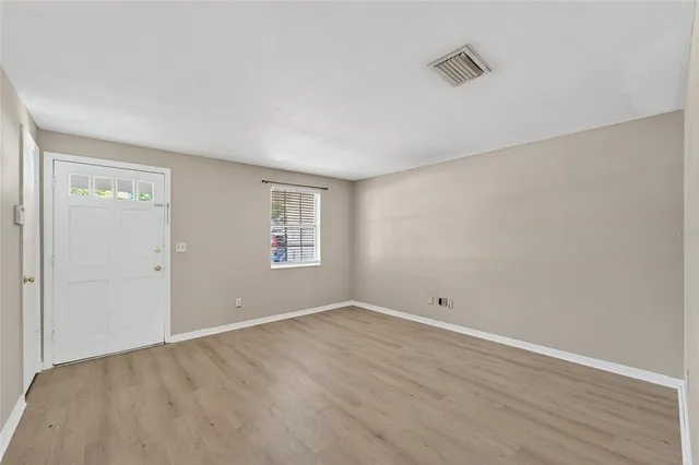a view of an empty room with wooden floor