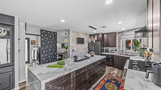 a kitchen with stainless steel appliances granite countertop a sink stove and refrigerator