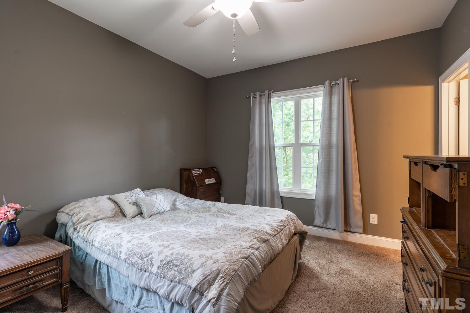 532 Cooper Street Clayton, NC 27520 - Photo 18 of 33 a bedroom with a bed and a flat tv screen on a dresser