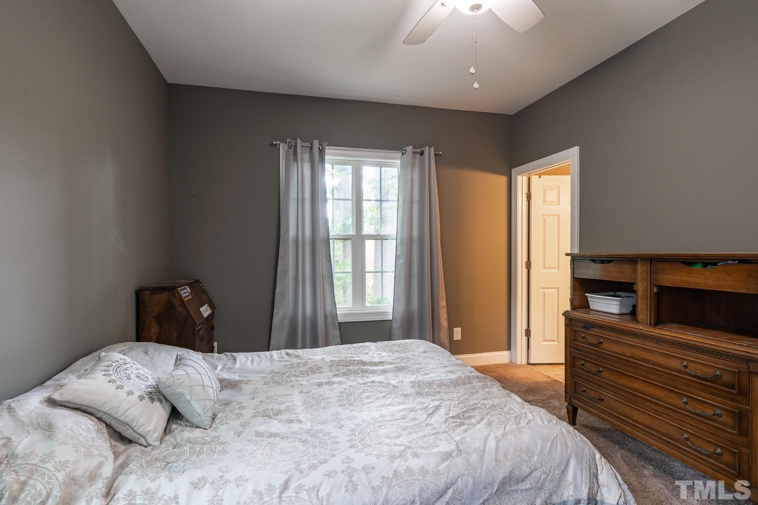 532 Cooper Street Clayton, NC 27520 - Photo 19 of 33 a bedroom with a bed and a chandelier