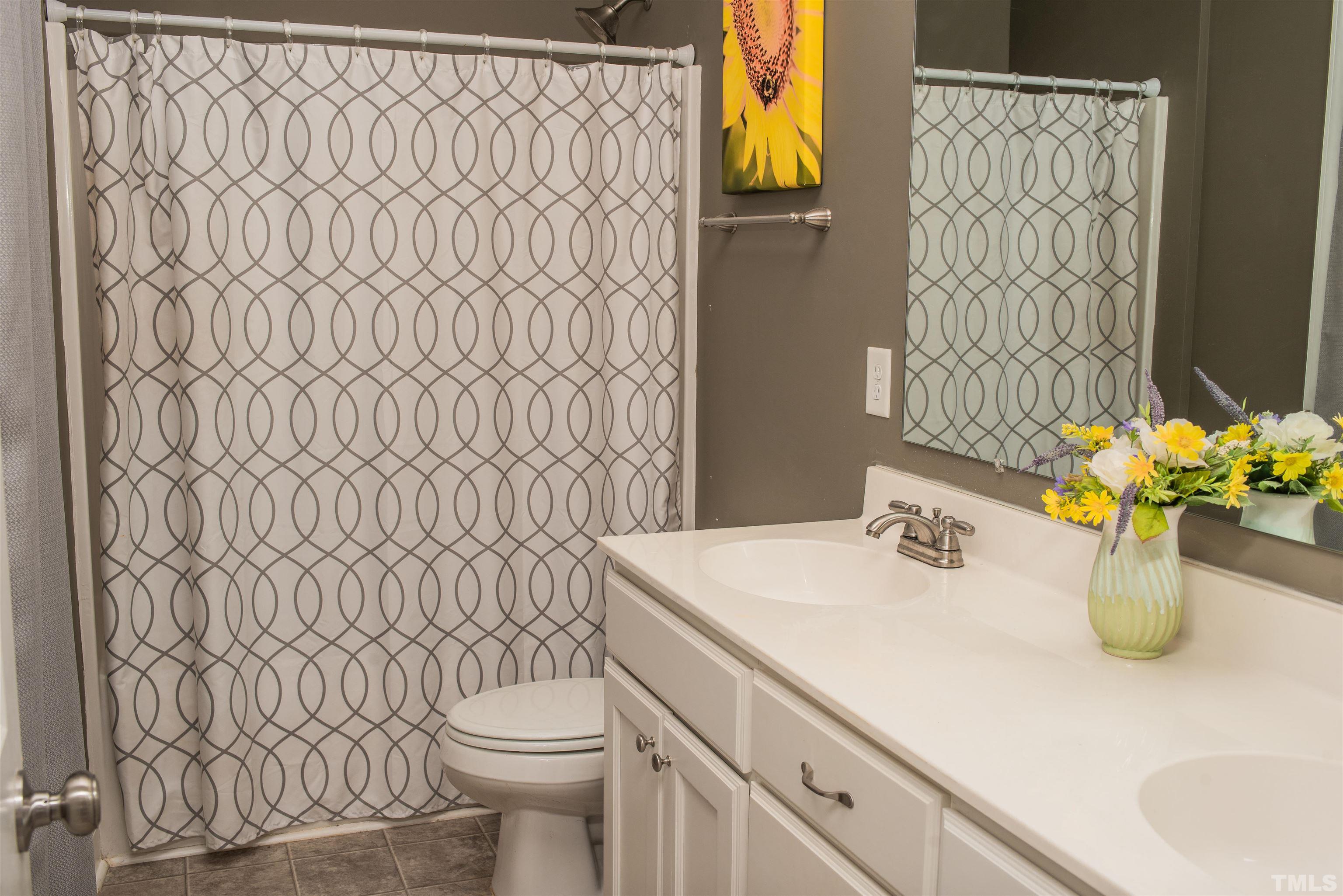 532 Cooper Street Clayton, NC 27520 - Photo 25 of 33 a bathroom with a sink a toilet and shower curtain