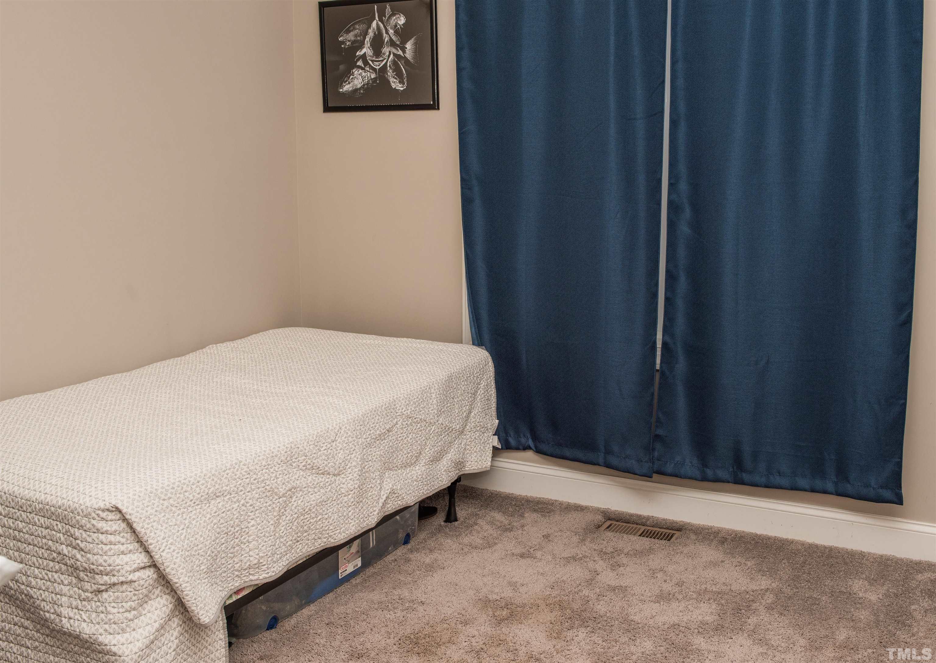 532 Cooper Street Clayton, NC 27520 - Photo 27 of 33 a bed sitting in a bedroom next to a wooden door