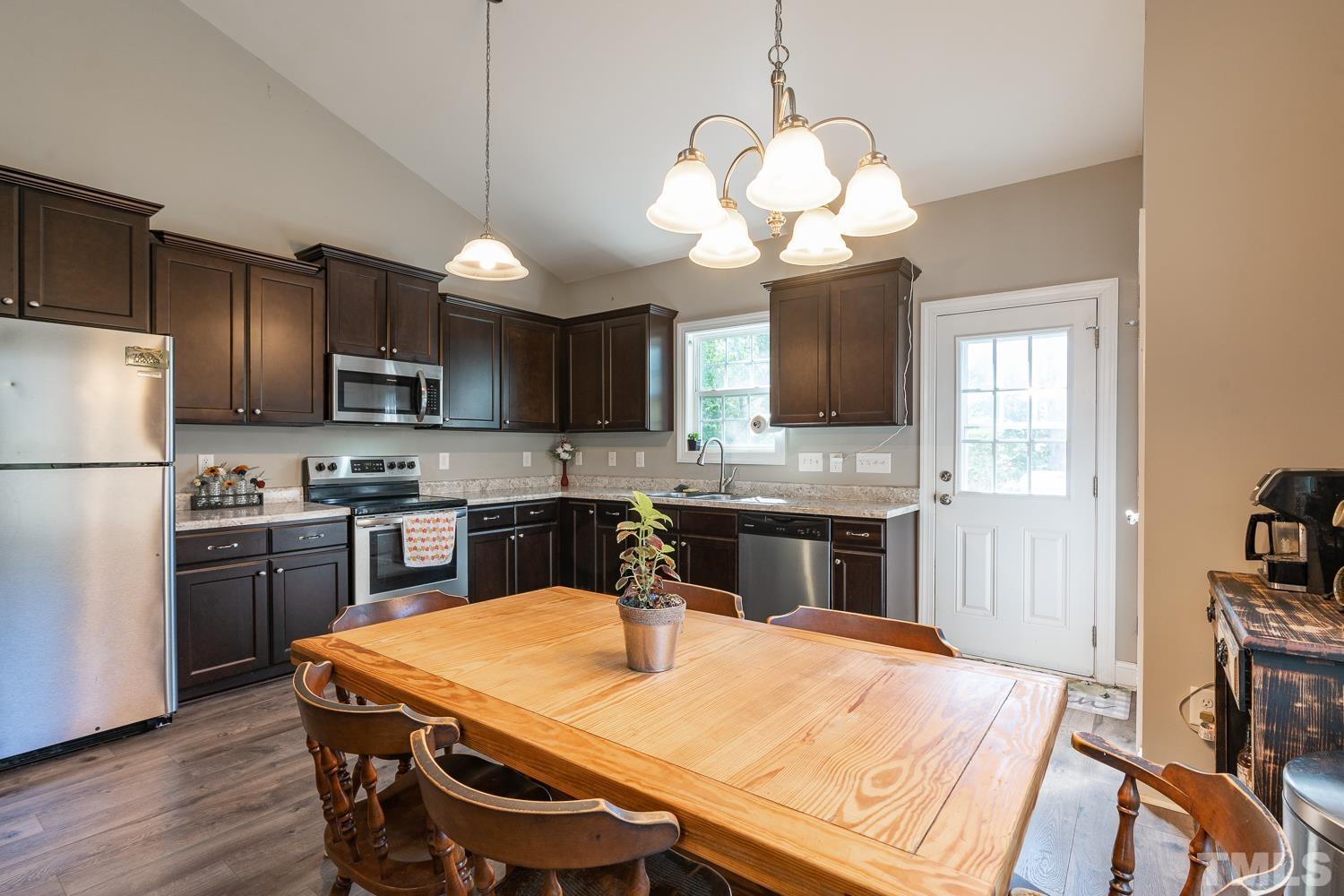 532 Cooper Street Clayton, NC 27520 - Photo 6 of 33 a kitchen with stainless steel appliances granite countertop a sink refrigerator stove and microwave