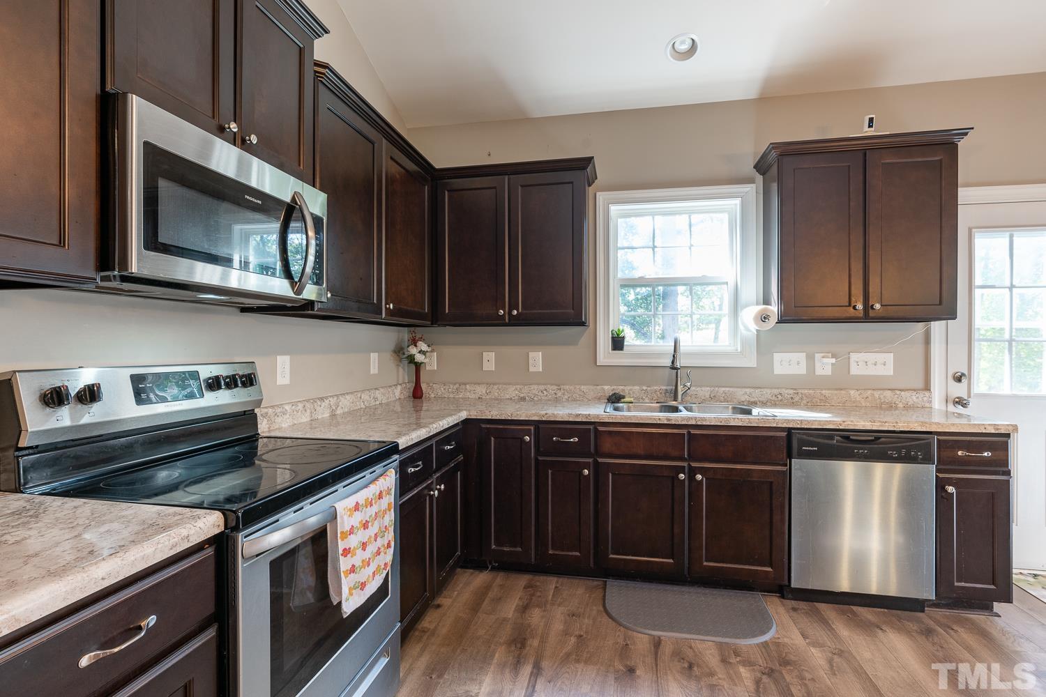 532 Cooper Street Clayton, NC 27520 - Photo 7 of 33 a kitchen with stainless steel appliances granite countertop a stove a sink and a microwave