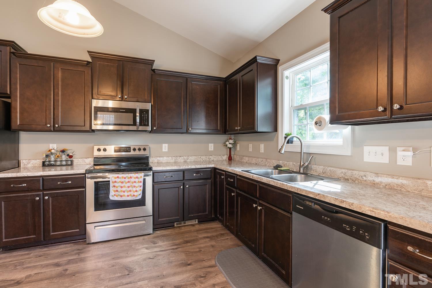 532 Cooper Street Clayton, NC 27520 - Photo 8 of 33 a kitchen with stainless steel appliances granite countertop a sink a stove and cabinets