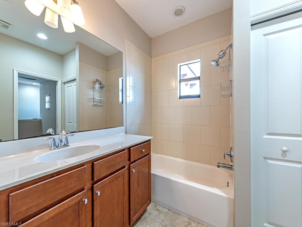 7777 Bristol Circle Naples, FL 34120 - Photo 13 of 22 a bathroom with a sink a vanity a mirror and a bathtub