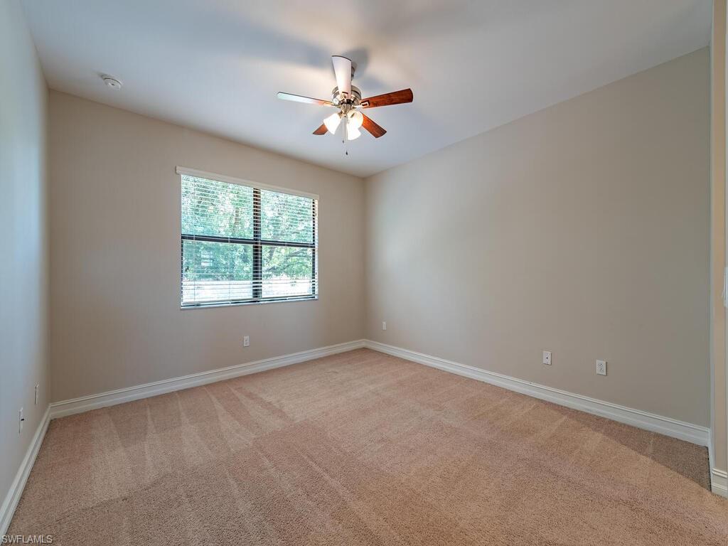 7777 Bristol Circle Naples, FL 34120 - Photo 14 of 22 an empty room with window and chandelier fan