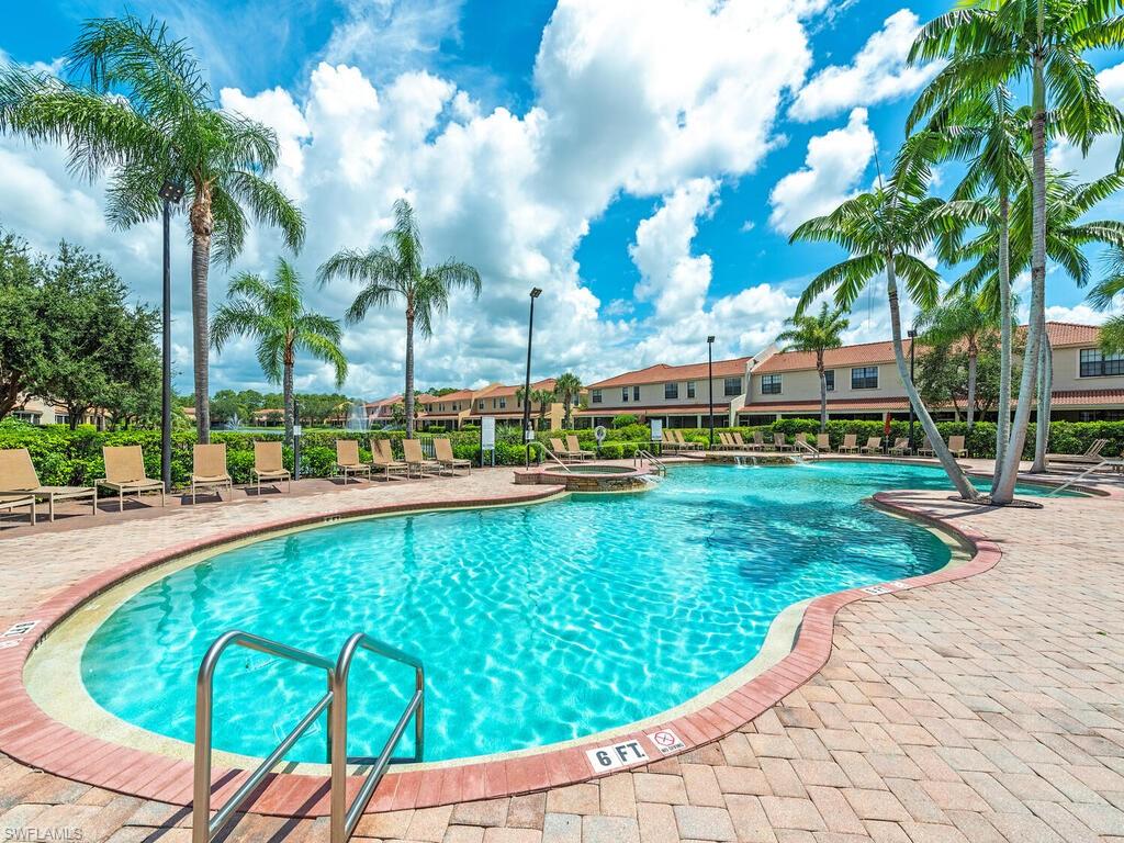 7777 Bristol Circle Naples, FL 34120 - Photo 21 of 22 a view of a swimming pool with a lawn chairs under palm trees