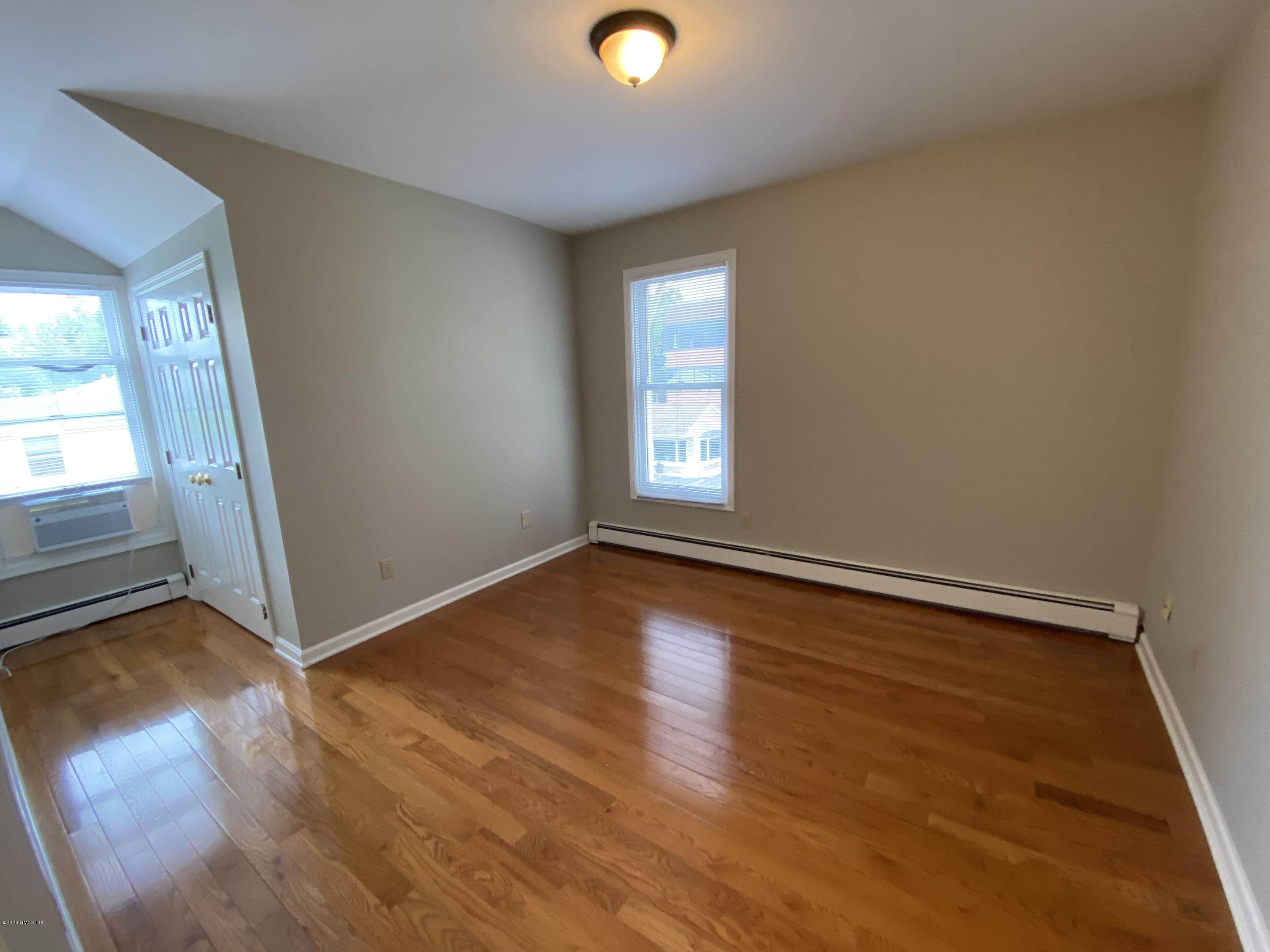 131 Mason Street, Unit 2 Greenwich, CT 06830 - Photo 11 of 14 an empty room with wooden floor and windows