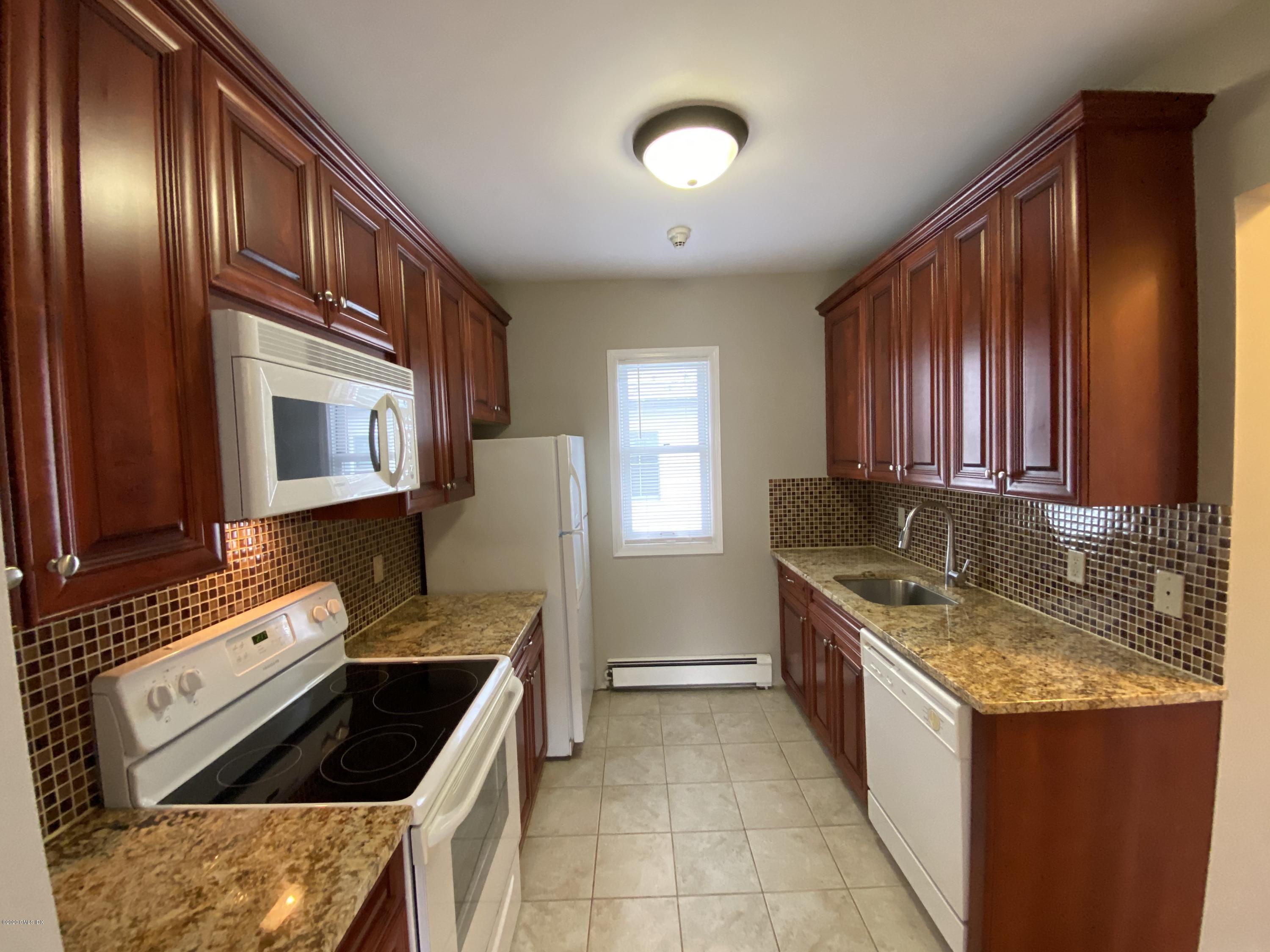 131 Mason Street, Unit 2 Greenwich, CT 06830 - Photo 8 of 14 a kitchen with granite countertop a stove sink and cabinets