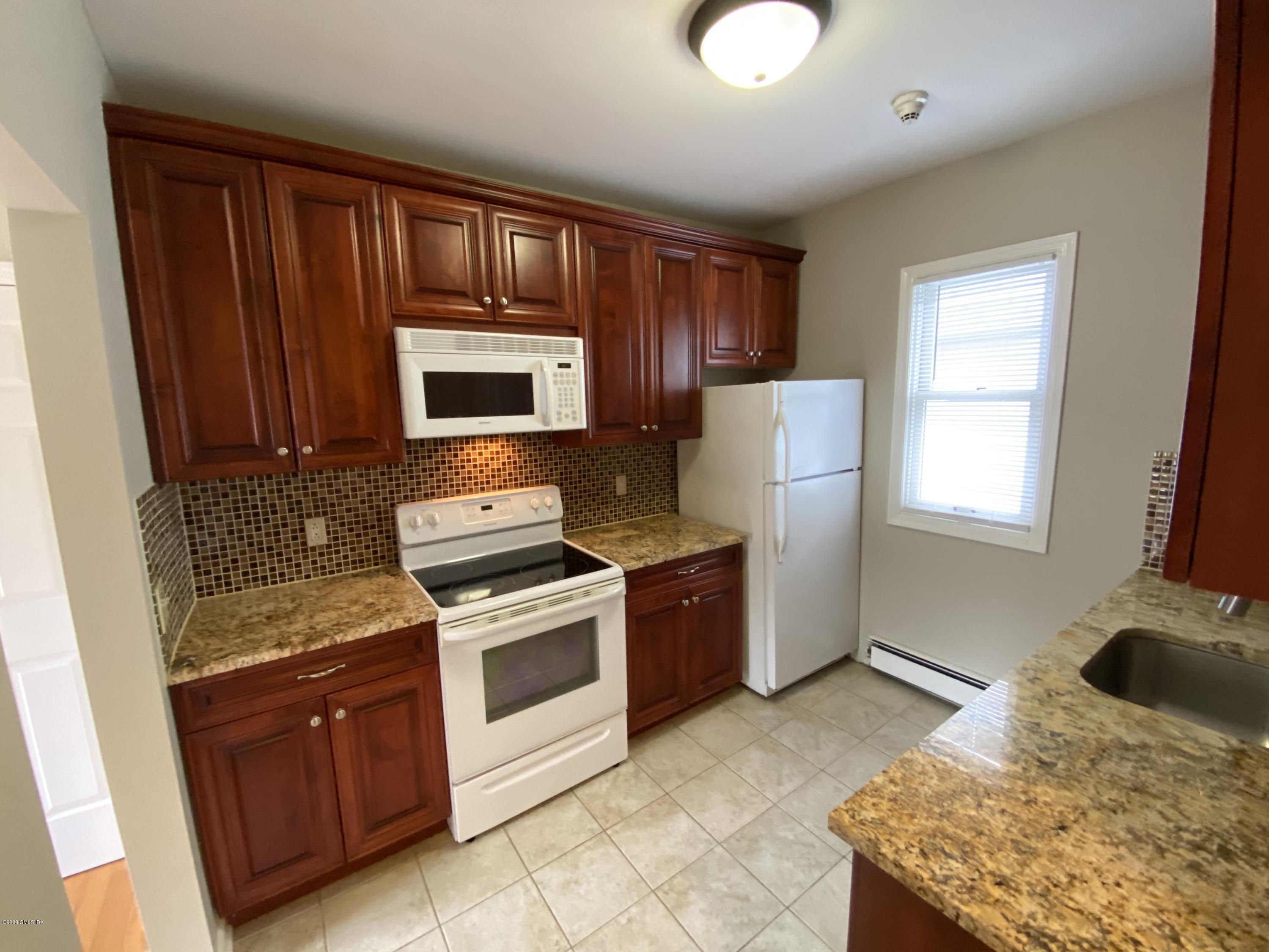 131 Mason Street, Unit 2 Greenwich, CT 06830 - Photo 9 of 14 a kitchen with stainless steel appliances granite countertop a stove sink and microwave
