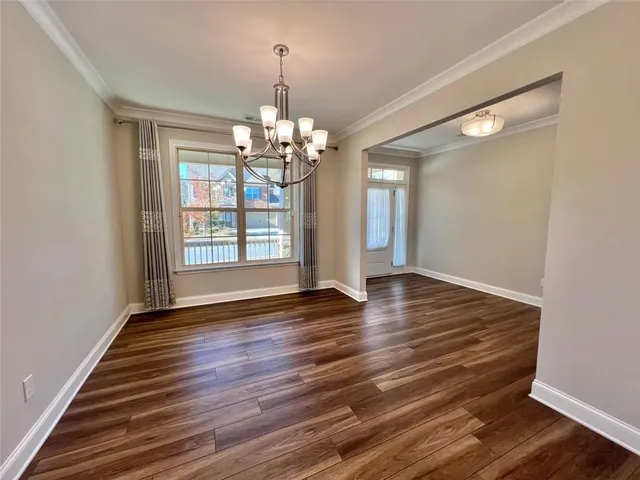 a view of a room with wooden floor chandelier and window