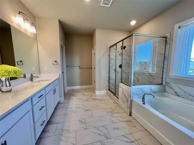 a large spacious bathroom with a granite countertop tub sink shower and mirror