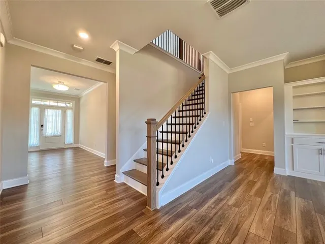 a view of a hallway with wooden floor and stairs