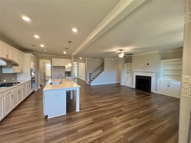 a view of kitchen living room with wooden floor and a fireplace