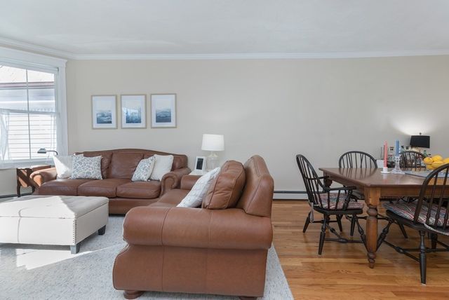 a view of a a dining room with furniture window and wooden floor