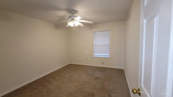 an empty room with a chandelier fan