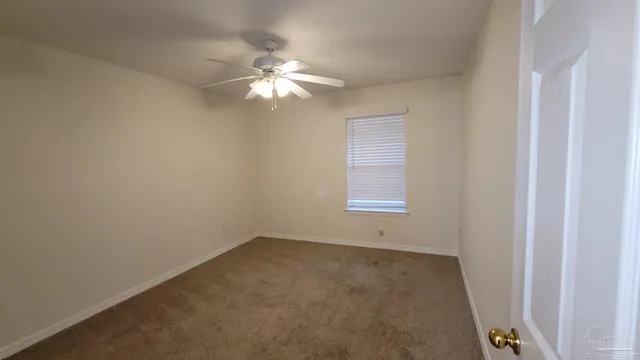 an empty room with a chandelier fan