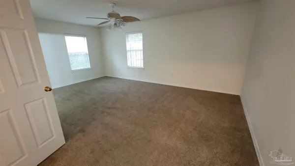 an empty room with windows & cabinet