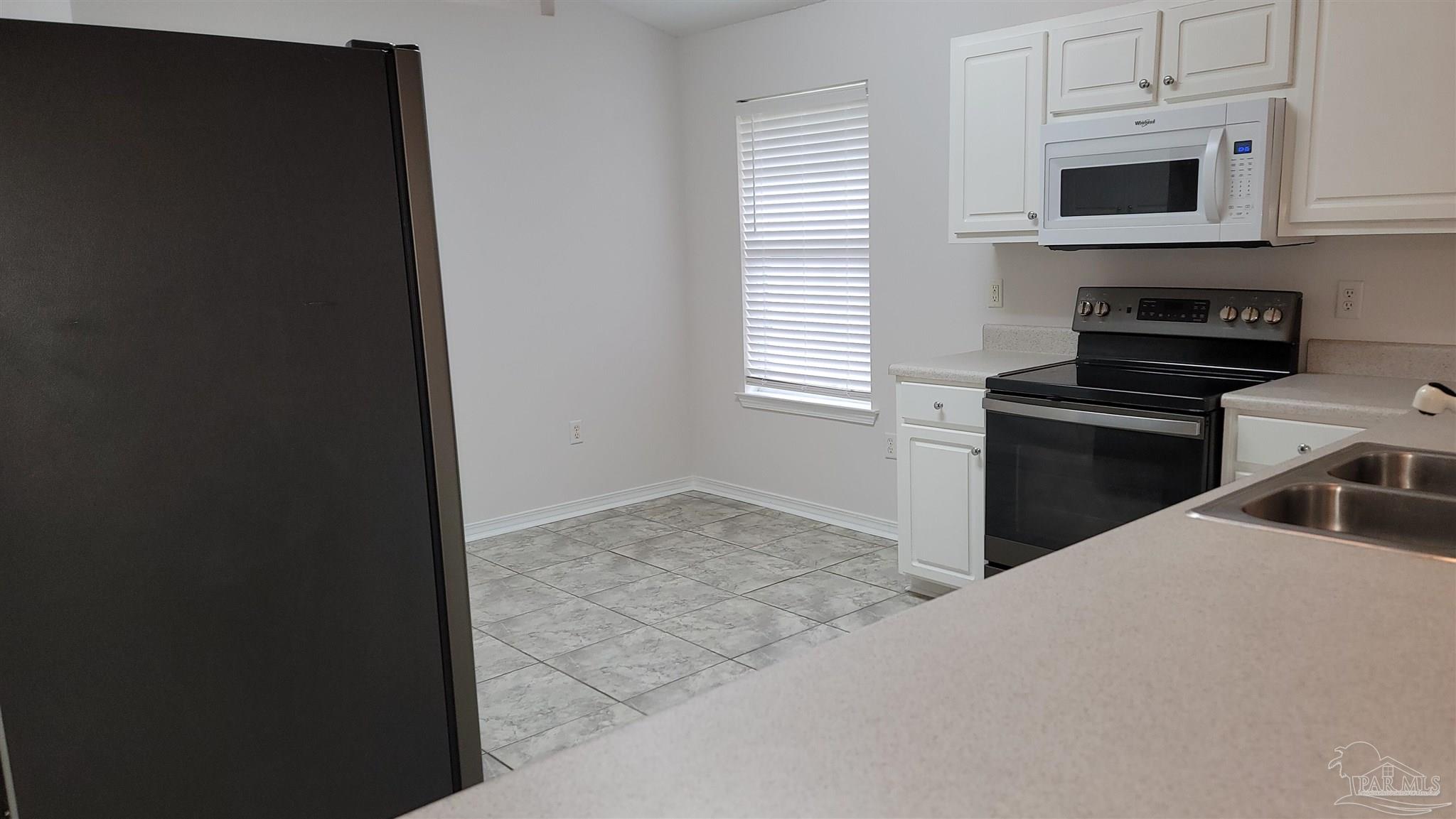 3741 Monopoly Court Gulf Breeze, FL 32563 - Photo 8 of 17 a kitchen with stainless steel appliances a sink a stove a microwave and cabinets