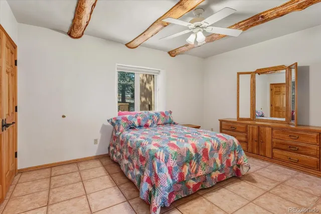 a bedroom with a bed a chandelier and dresser