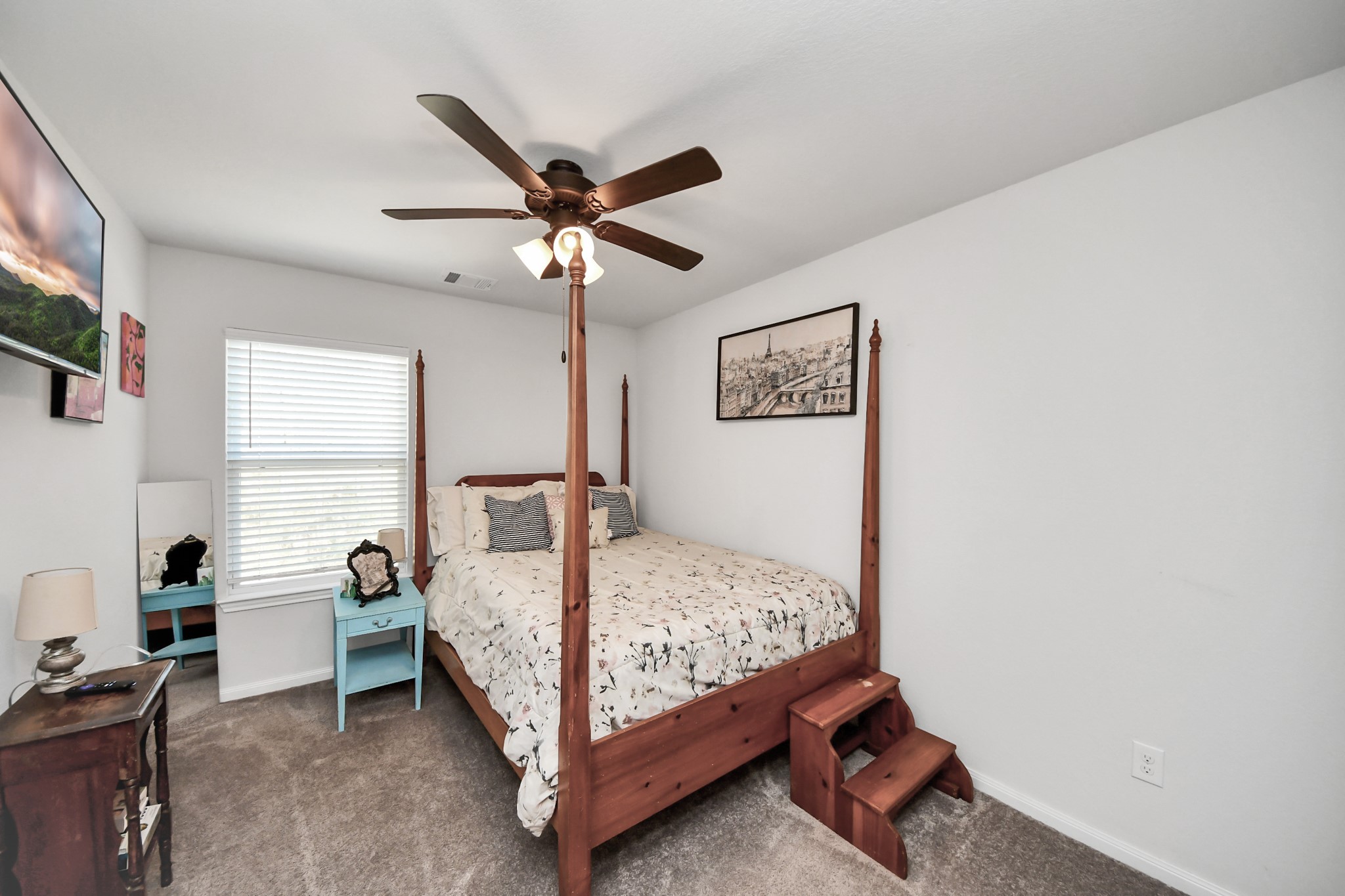 15291 Arrowhead Loop West Willis, TX 77378 - Photo 14 of 28 Cozy bedroom featuring a four-poster bed, ceiling fan, and ample natural light from a large window.