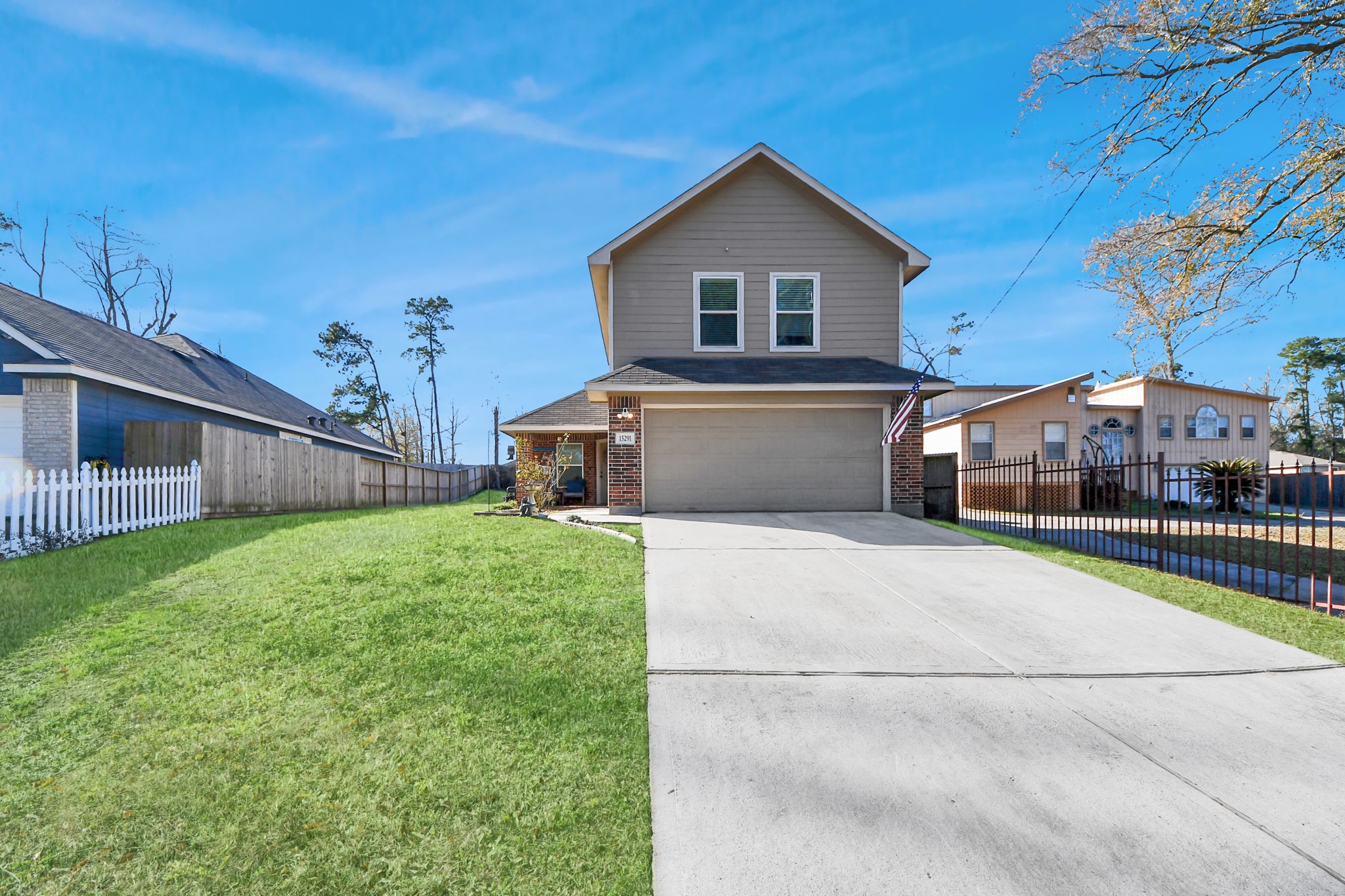 15291 Arrowhead Loop West Willis, TX 77378 - Photo 3 of 28 Charming two-story home with a spacious garage and well-maintained front lawn. The exterior features a blend of brick and siding, complemented by a welcoming front porch. Situated in a quiet neighborhood with a fenced backyard for added privacy.