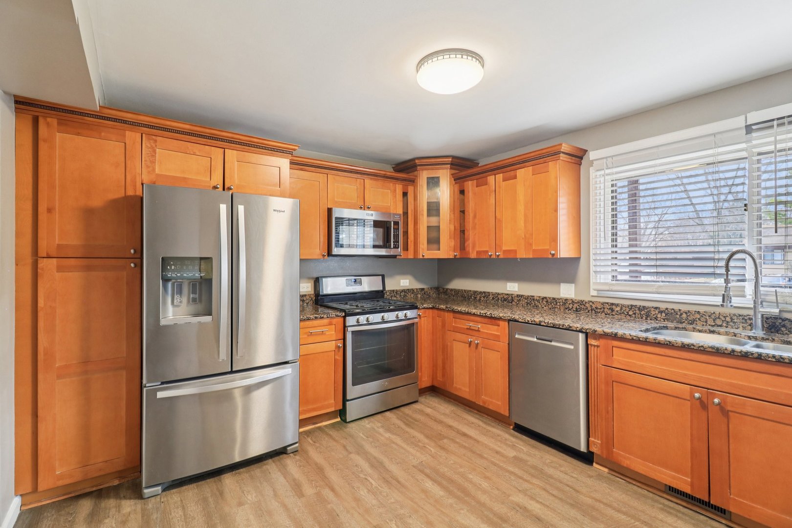 75 Mineola Road, Unit 75 Fox Lake, IL 60020 - Photo 11 of 33 a kitchen with stainless steel appliances granite countertop a refrigerator a sink dishwasher a stove and white countertops with wooden floor