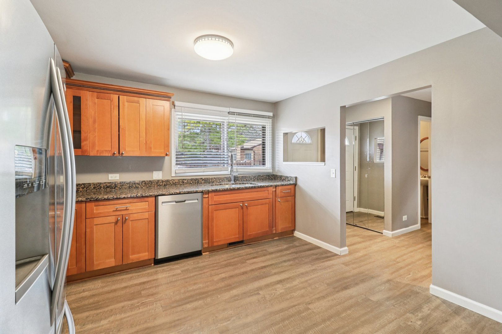 75 Mineola Road, Unit 75 Fox Lake, IL 60020 - Photo 12 of 33 a kitchen with granite countertop wooden floors and white appliances