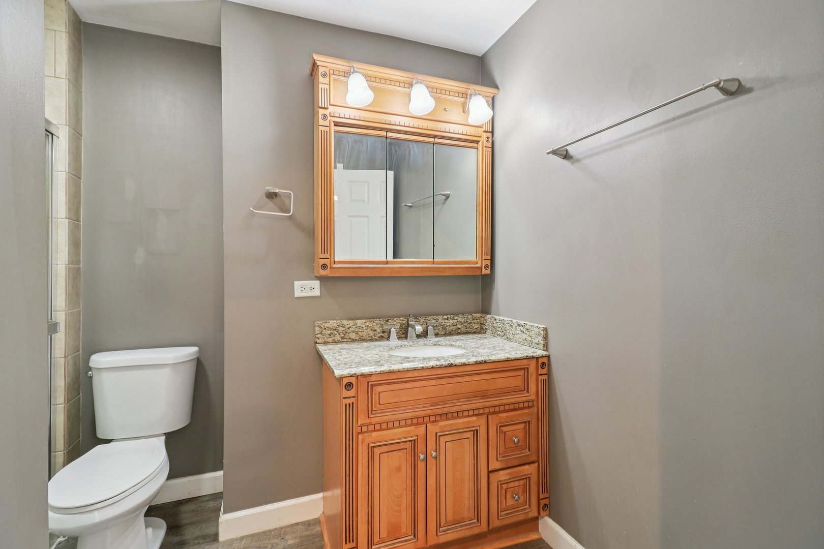 75 Mineola Road, Unit 75 Fox Lake, IL 60020 - Photo 19 of 33 a bathroom with a toilet a sink and a mirror