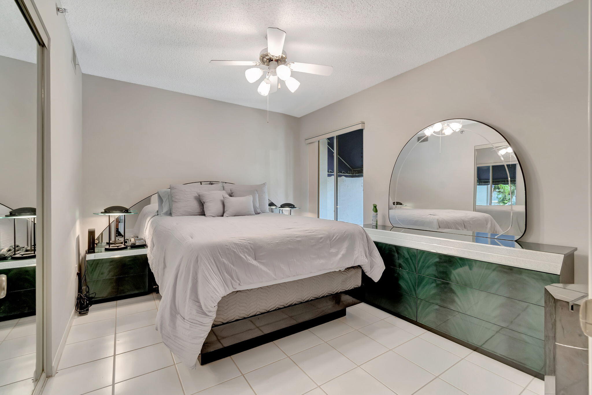 280 Northwest 67th Street, Unit B 207 Boca Raton, FL 33487 - Photo 8 of 13 a bedroom with a bed and a chandelier