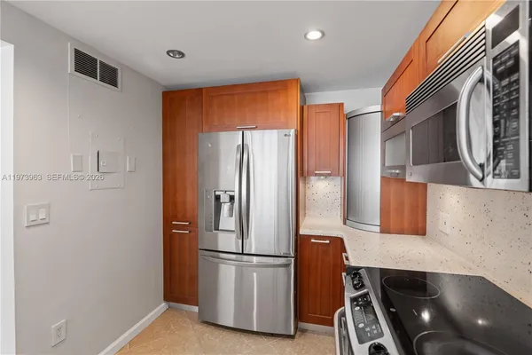a kitchen with stainless steel appliances a refrigerator and a stove top oven