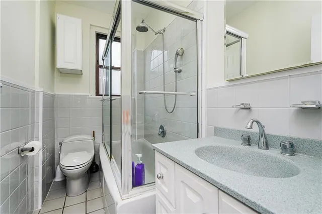 a bathroom with a granite countertop sink a toilet and shower