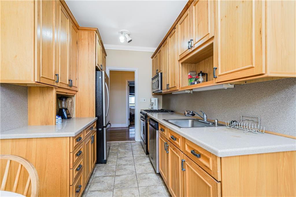351 Marine Avenue, Unit F11 Brooklyn, NY 11209 - Photo 8 of 23 a kitchen with stainless steel appliances granite countertop a sink and dishwasher refrigerator a oven with wooden cabinets