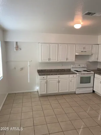 a kitchen with white cabinets a sink and dishwasher