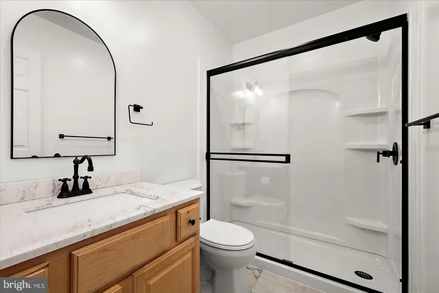 an empty room with chandelier fan and window