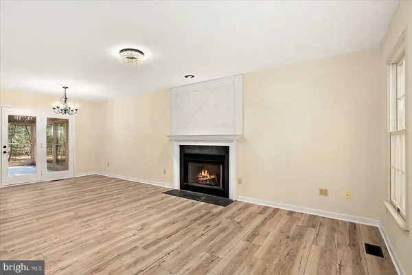 a view of an empty room with window and wooden floor